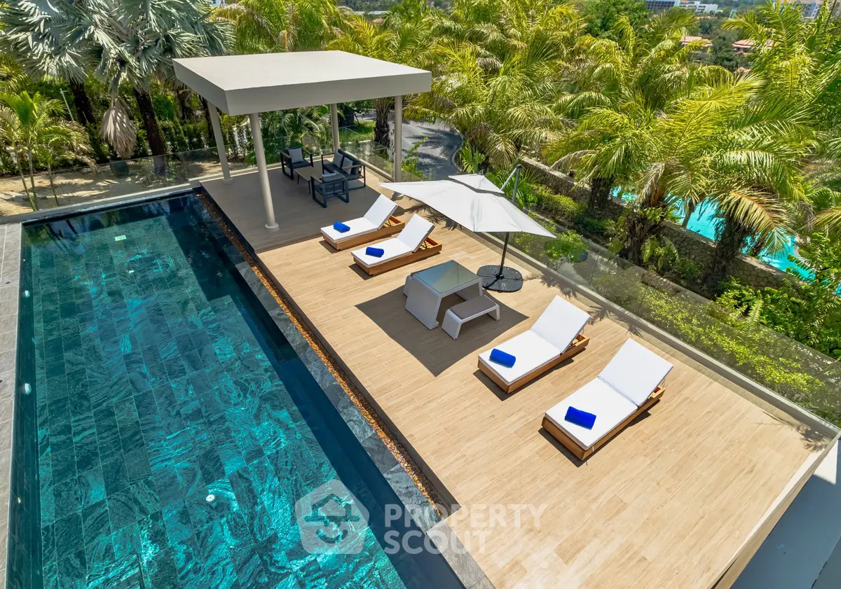 Luxurious rooftop pool with sun loungers and lush greenery, perfect for relaxation and leisure.
