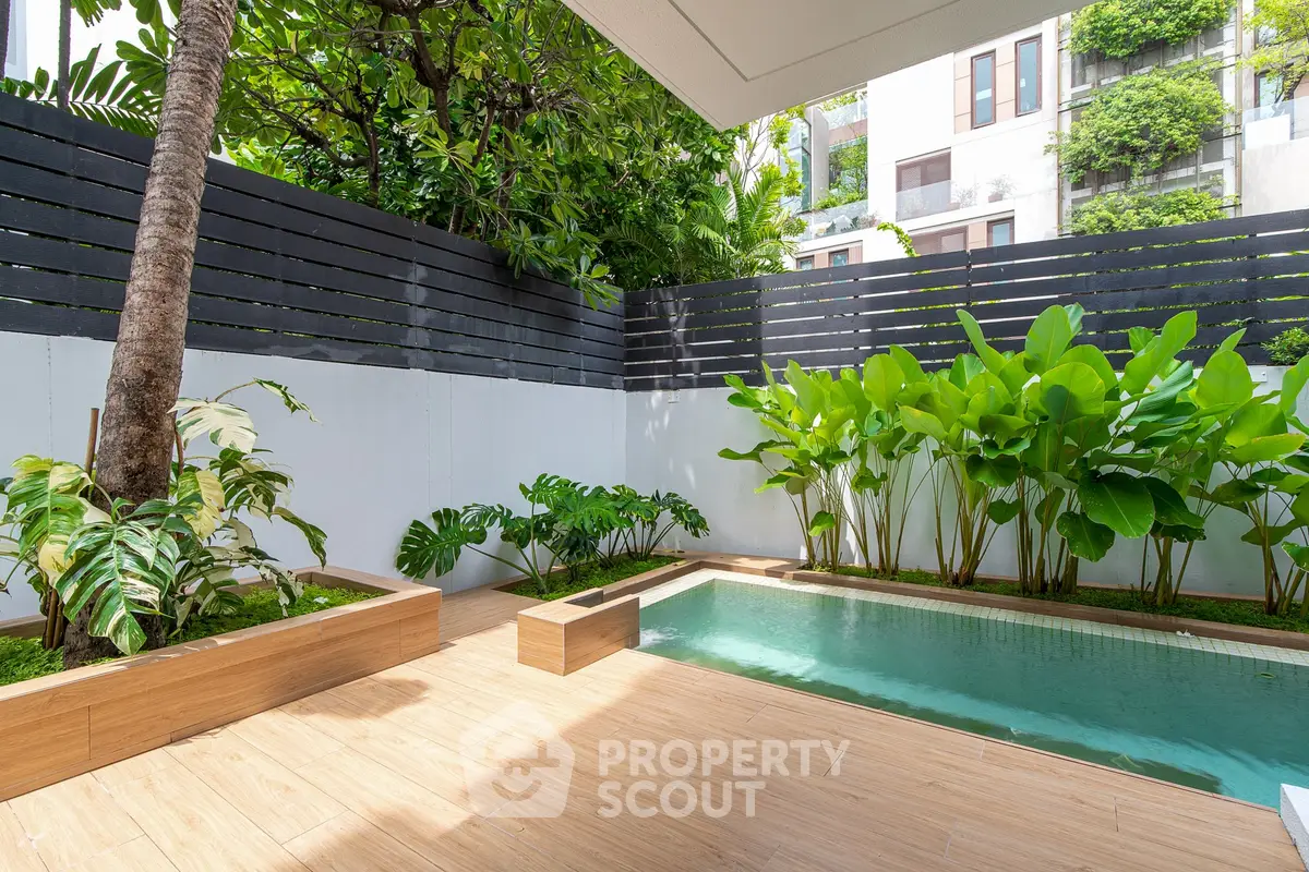 Luxurious private garden with pool and lush greenery in modern residential complex.