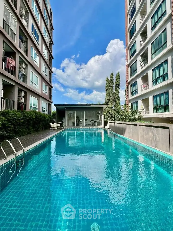 Stunning condominium pool area with modern architecture and clear blue skies.