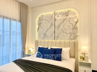 Luxurious bedroom with elegant marble accent wall and plush bedding