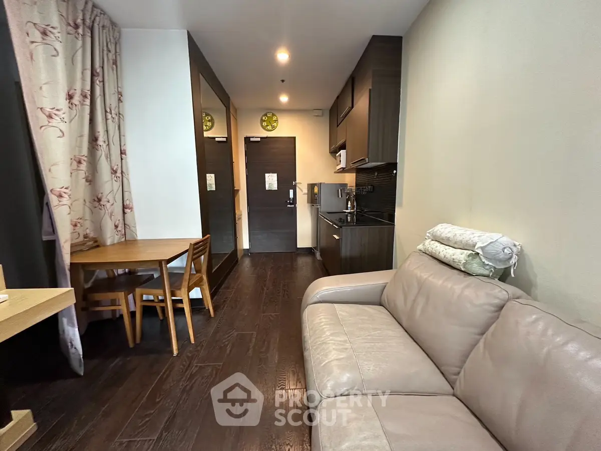 Cozy living room with modern kitchen and dining area in open layout apartment.