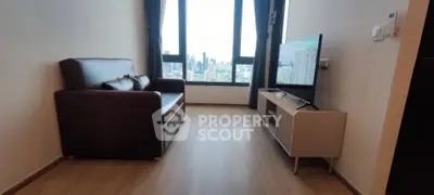 Modern living room with city view, featuring sleek furniture and large windows.