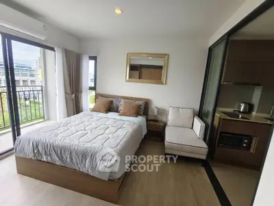 Modern bedroom with balcony and kitchenette in urban apartment