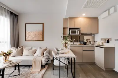 Modern open-plan living room and kitchen with elegant decor and natural light.