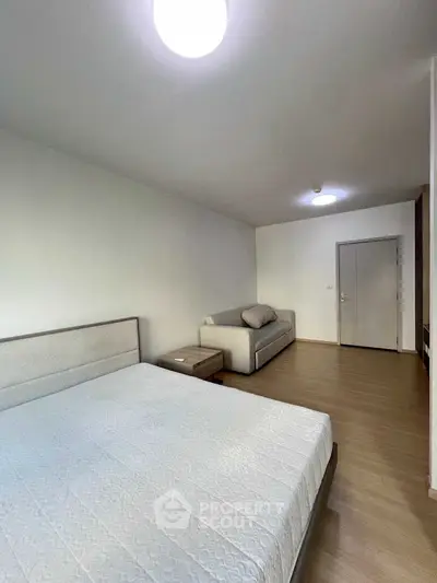 Spacious bedroom with modern furnishings and cozy ambiance in a stylish apartment.