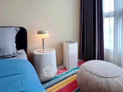Cozy bedroom with modern decor, featuring a stylish lamp and air purifier for a comfortable living environment.