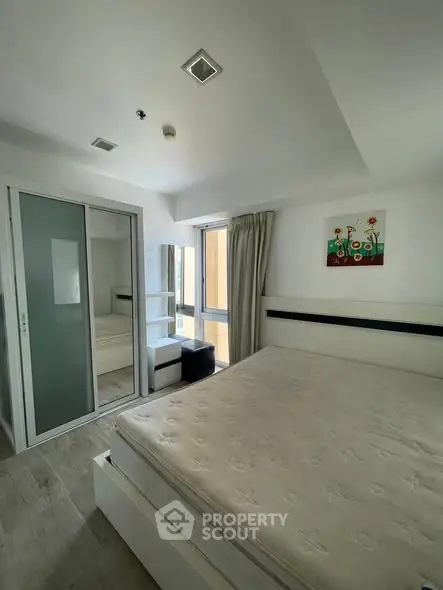 Modern bedroom with large bed and mirrored closet in bright apartment