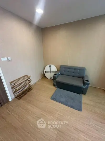 Cozy living room with modern sofa and wooden flooring, perfect for relaxation.