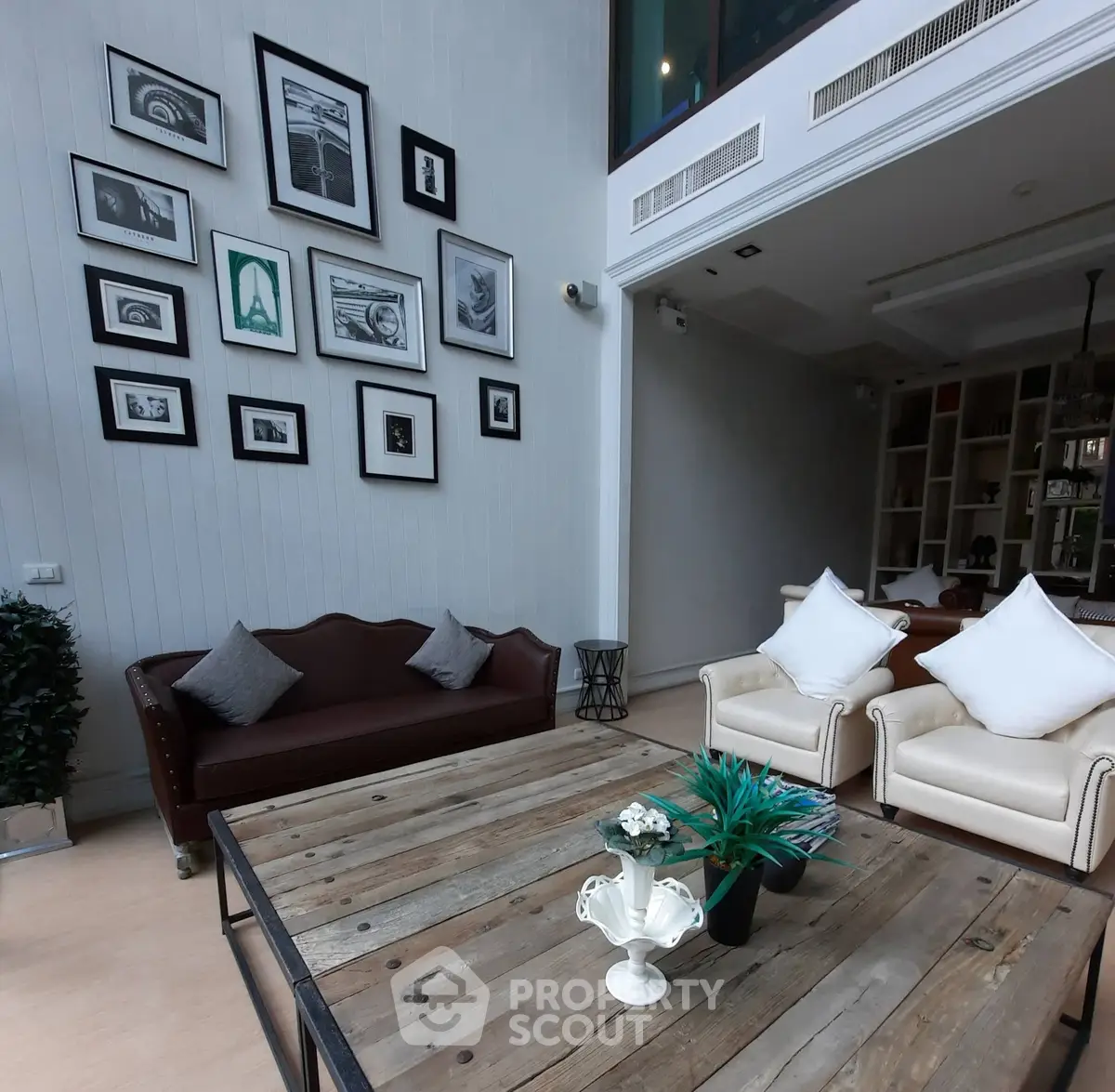 Stylish living room with high ceiling, elegant furniture, and wall art in modern home.