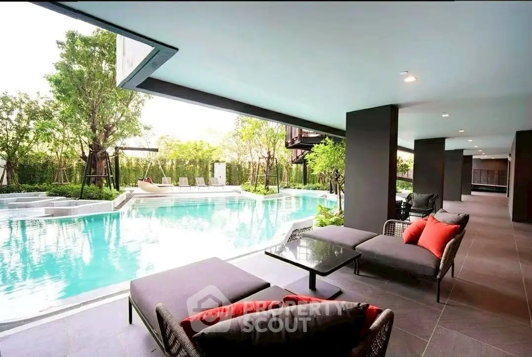 Luxurious poolside lounge area with modern seating and lush greenery, perfect for relaxation and leisure.