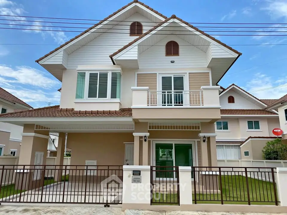 Charming two-story house with spacious balcony and manicured lawn in a serene neighborhood.