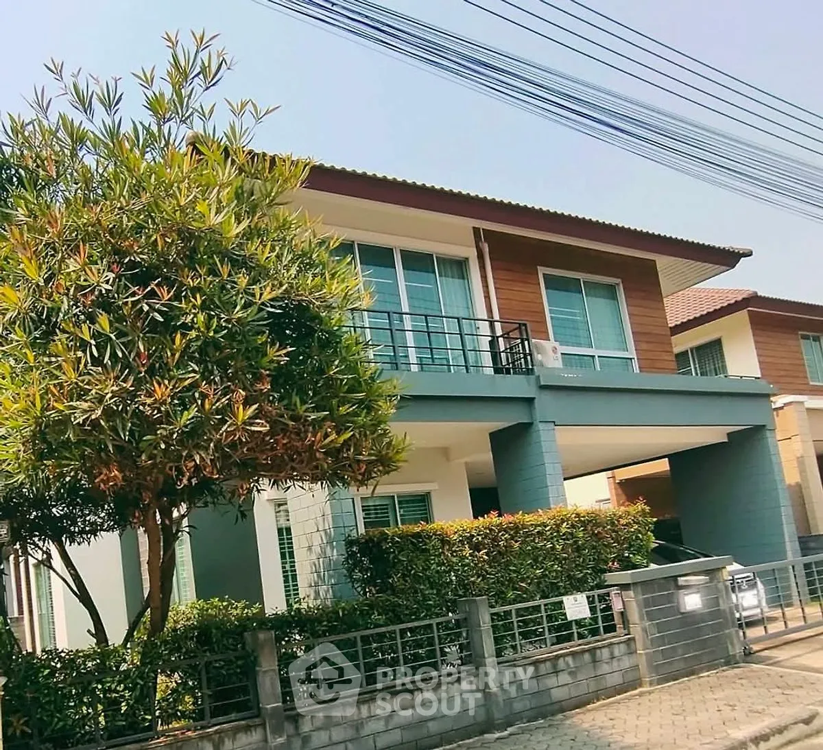 Modern two-story house with lush greenery and spacious driveway in a serene neighborhood.