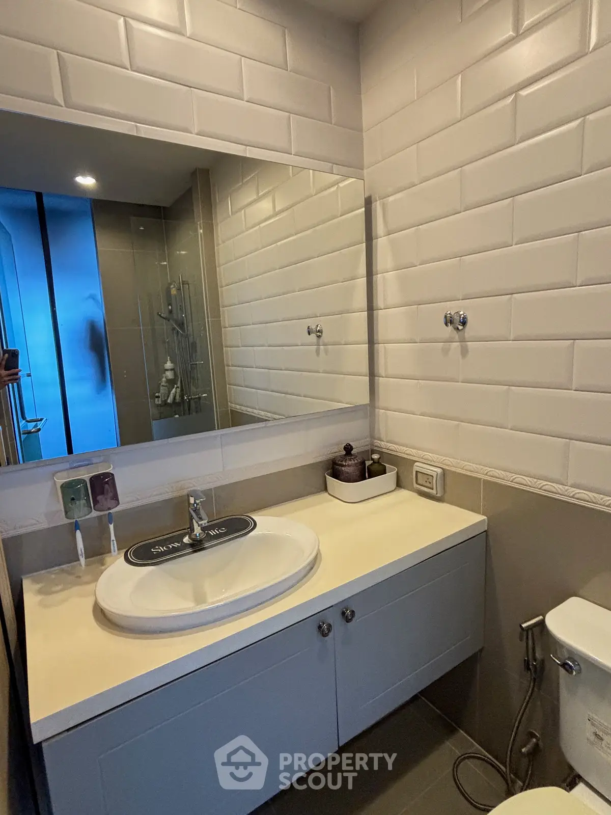 Modern bathroom with sleek vanity and large mirror in stylish apartment.
