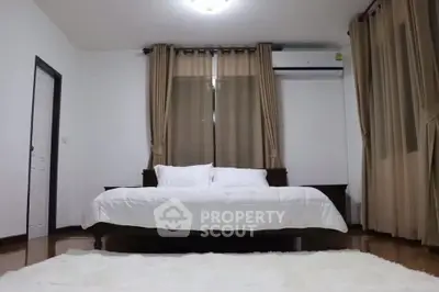 Spacious bedroom with elegant curtains and cozy bed setup