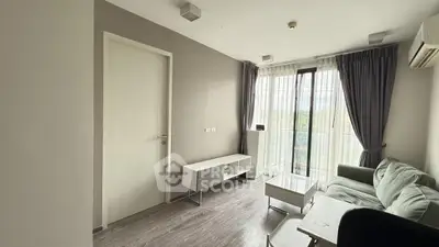 Modern living room with sleek furniture and large windows offering natural light.