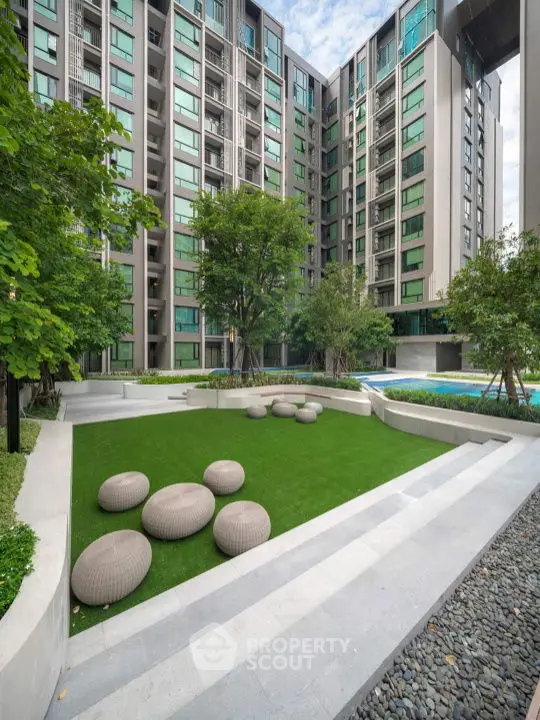 Modern apartment building with landscaped garden and unique seating area.