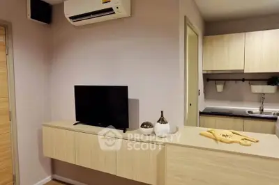 Modern living room with sleek TV setup and stylish kitchen area