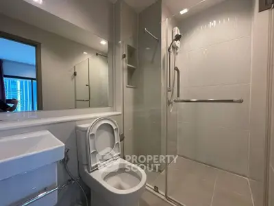 Modern bathroom with glass shower and sleek fixtures in a contemporary apartment.