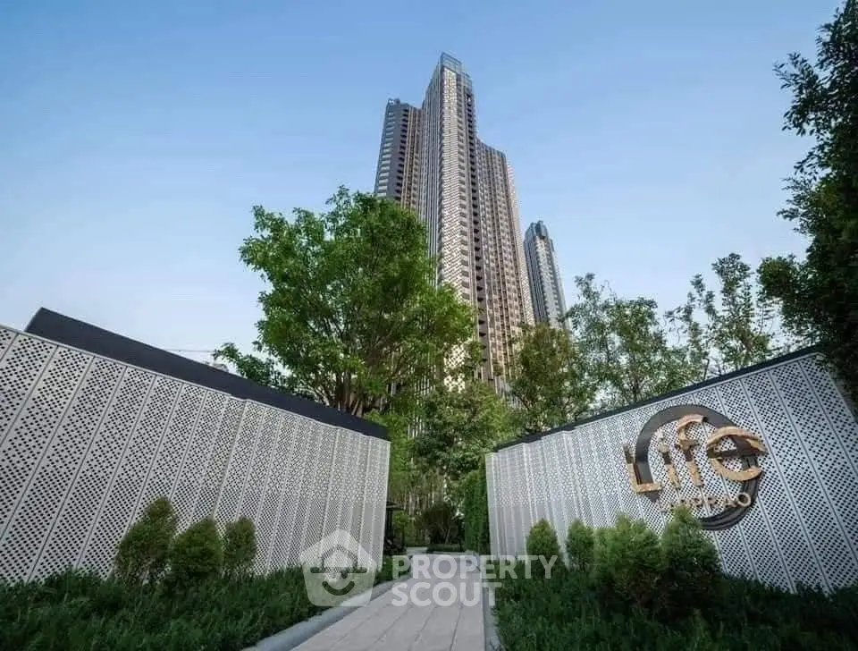 Stunning high-rise building with lush greenery and modern design entrance in urban setting.