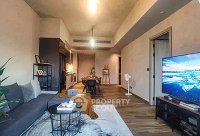 Modern living room with open kitchen, stylish decor, and large TV, perfect for contemporary urban living.