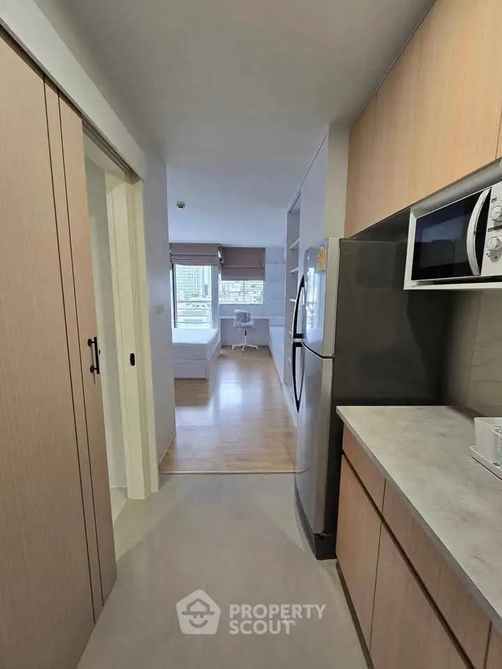 Modern apartment interior with sleek kitchen and cozy bedroom view.