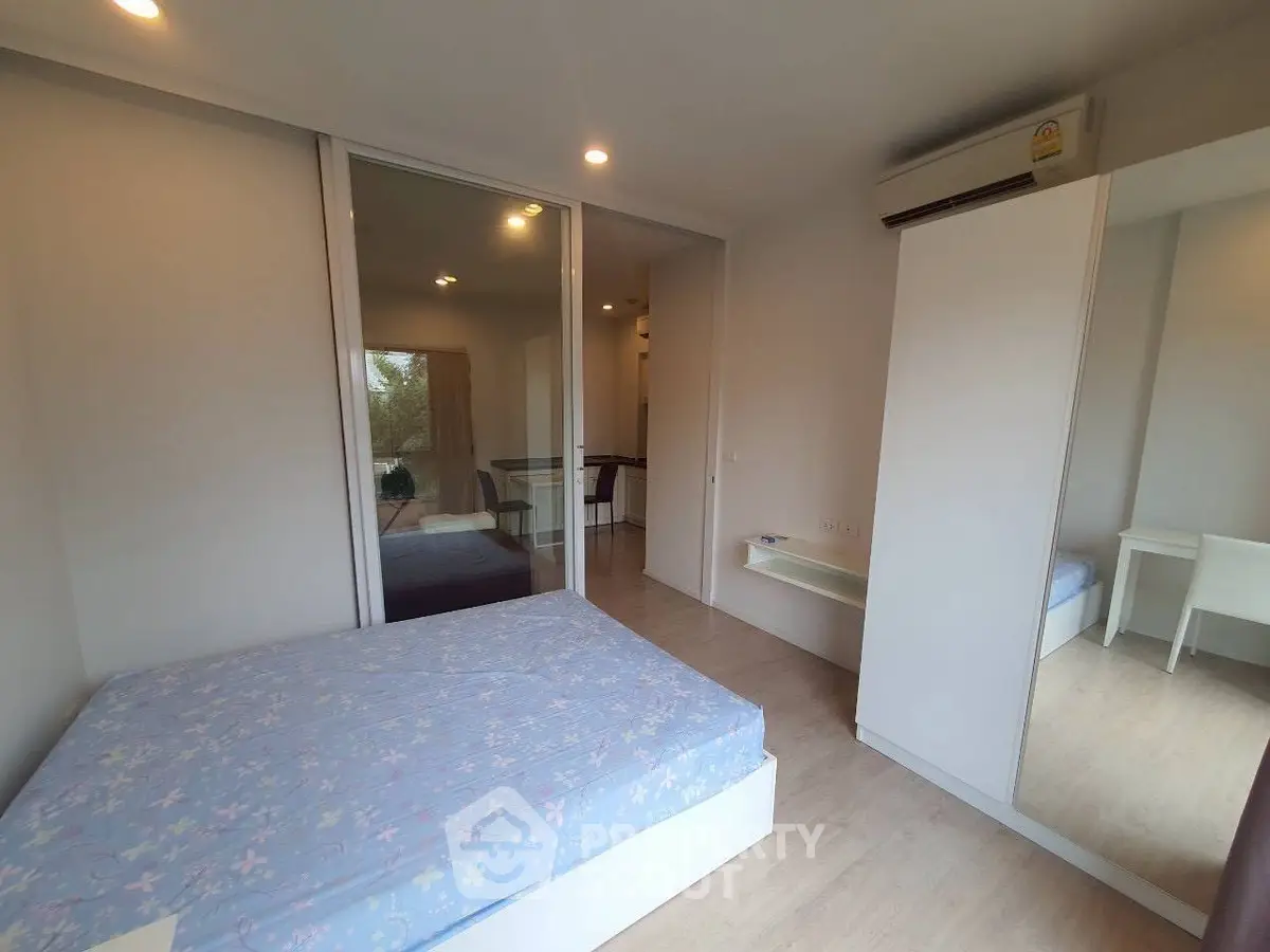 Modern bedroom with mirrored wardrobe and air conditioning in a cozy apartment.