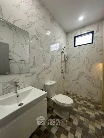 Modern bathroom with marble tiles and sleek fixtures in a contemporary home.
