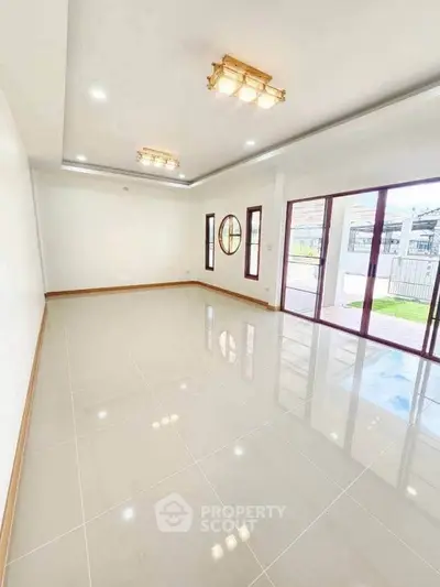 Spacious modern living room with large windows and elegant lighting in a luxury home.