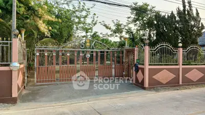 Charming gated entrance with lush greenery and elegant ironwork, perfect for privacy and curb appeal.