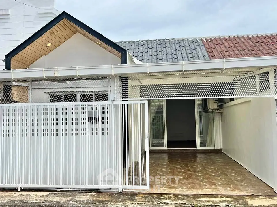 Charming single-story home with gated entrance and tiled driveway, perfect for cozy living.