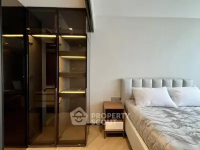 Modern bedroom with sleek glass wardrobe and cozy bed setup