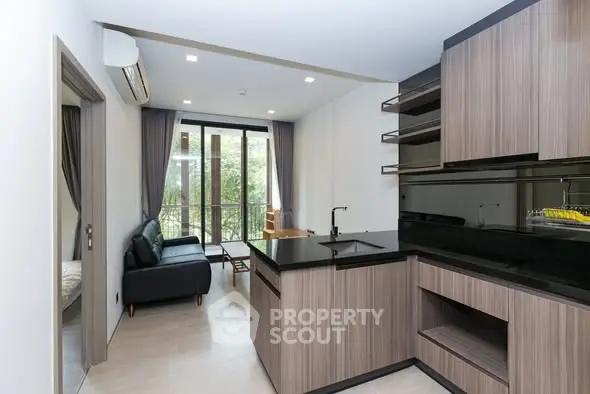 Modern open-layout kitchen with sleek cabinetry and cozy living area.