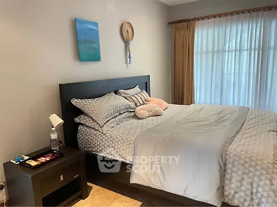 Cozy bedroom with modern decor and large window for natural light.