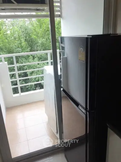 Modern apartment balcony with fridge and lush green view