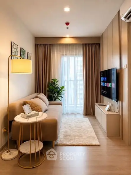 Modern living room with cozy sofa, stylish decor, and large window for natural light.