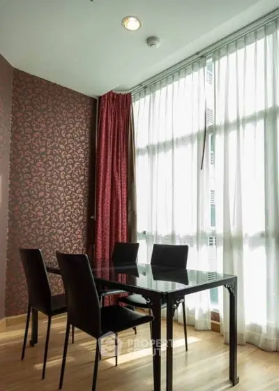 Elegant dining area with modern glass table and stylish chairs, featuring floor-to-ceiling windows and chic wallpaper.