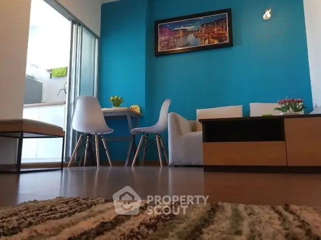 Modern living room with vibrant blue accent wall and stylish furniture