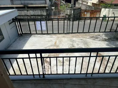 Spacious balcony with sturdy railing and urban street view, ideal for outdoor relaxation.