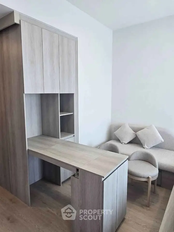 Modern minimalist living room with sleek wooden furniture and cozy seating area.