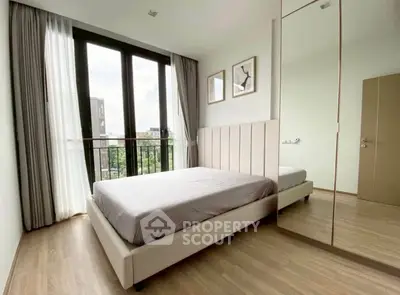 Modern bedroom with large windows and minimalist decor in a stylish apartment.