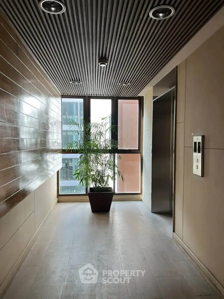 Modern apartment corridor with elevator and large window view