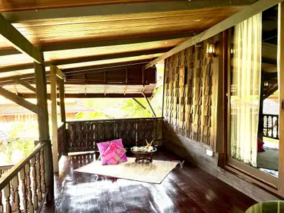 Charming wooden balcony with cozy seating and lush garden view