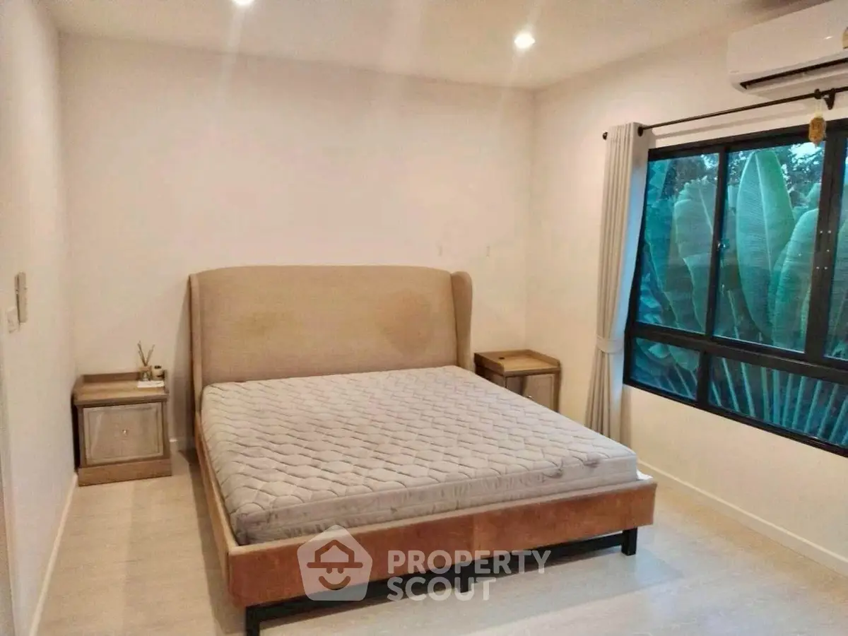 Spacious bedroom with large window and modern decor
