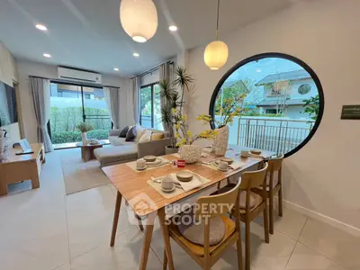 Modern living room with stylish dining area and large windows overlooking garden