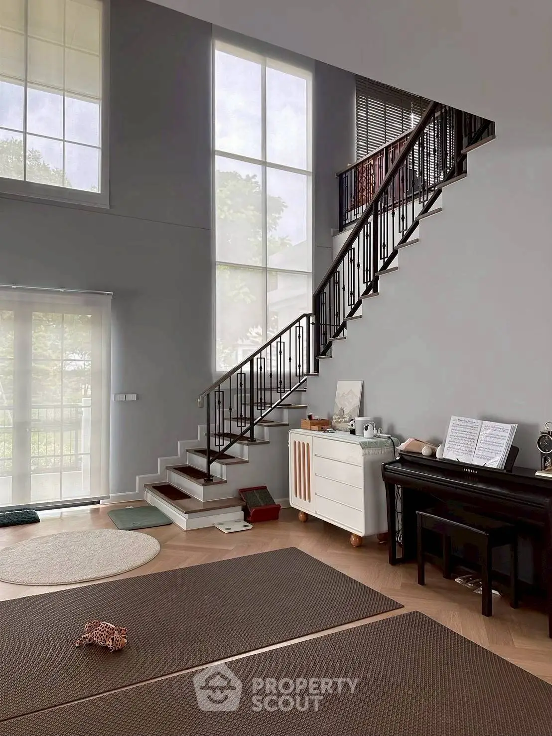 Spacious modern living room with high ceilings and elegant staircase