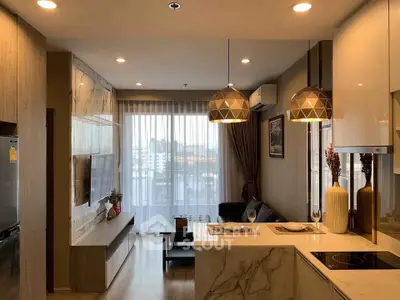 Modern living room with open kitchen, stylish lighting, and large window view.
