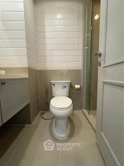 Modern bathroom with sleek white tiles and contemporary fixtures.