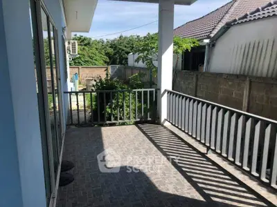 Charming balcony with tiled flooring and garden view, perfect for relaxation.
