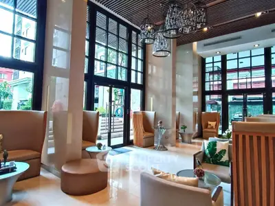 Luxurious modern lobby with high ceilings and elegant chandeliers in upscale building.