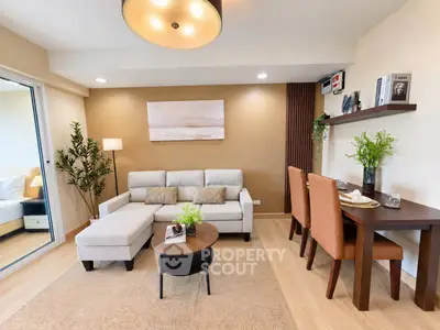 Modern living room with cozy seating and dining area, featuring elegant decor and natural lighting.